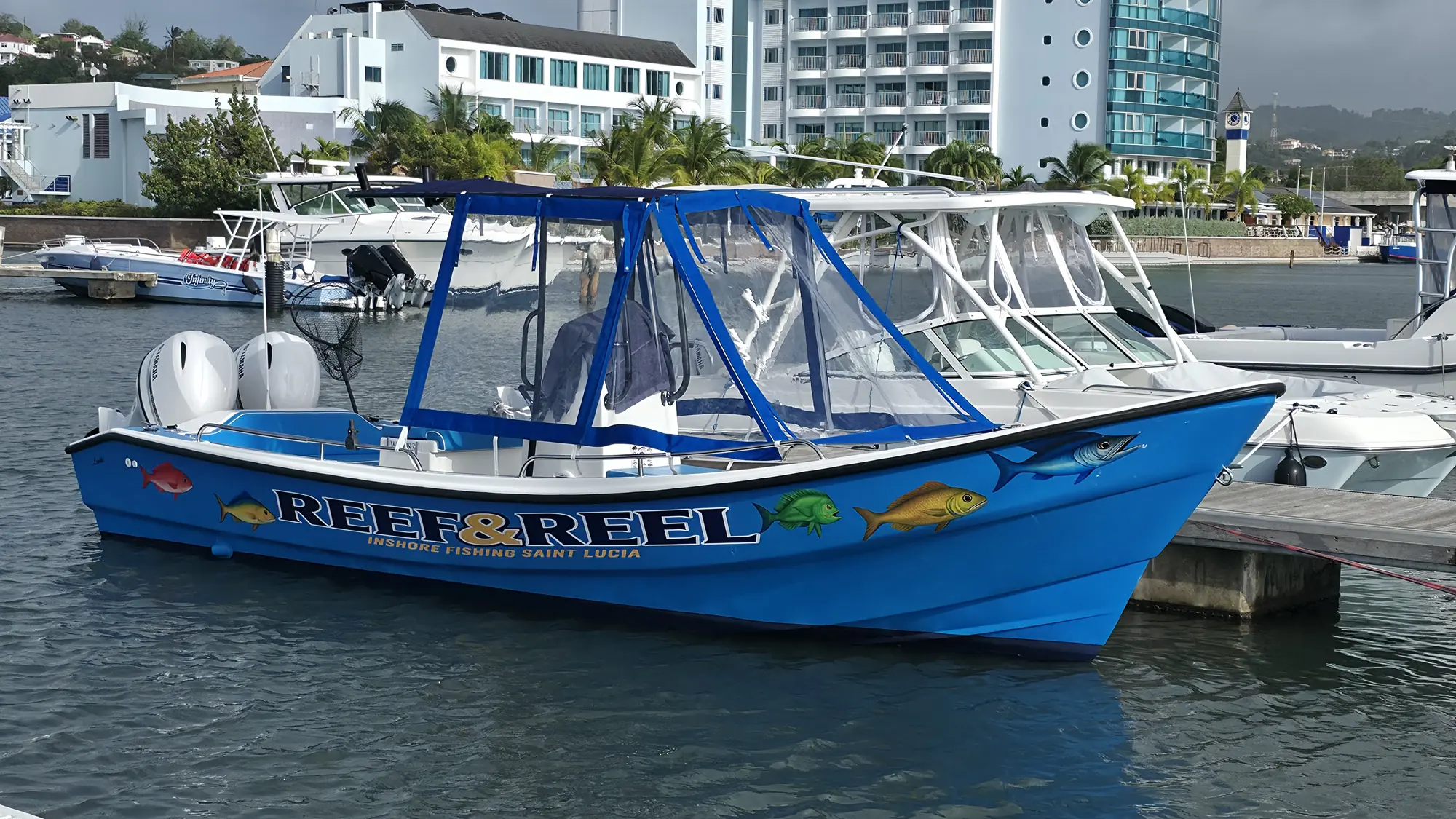The bright blue Reef & Reel boat moored at Rodney Bay Marina, with its shade canopy up