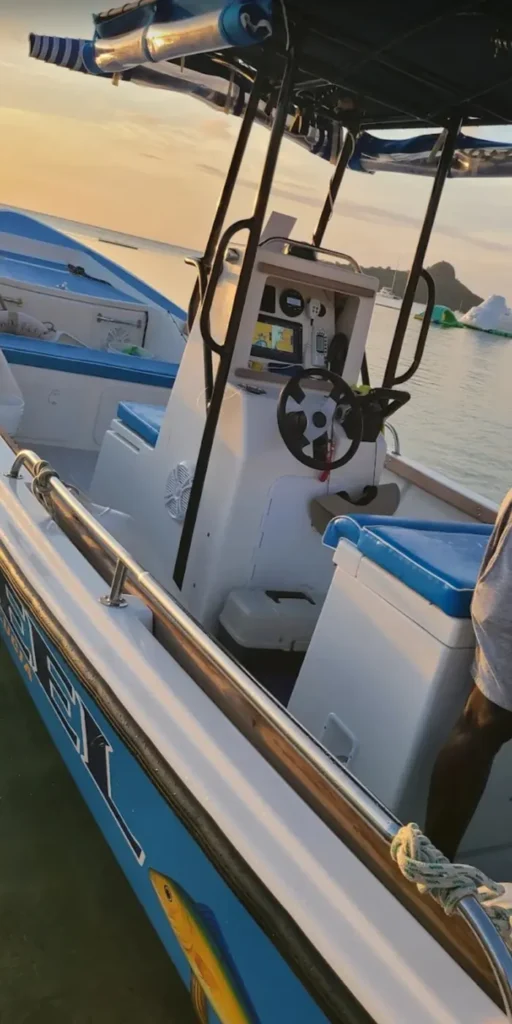 The boat's helm and navigation screen at sunset